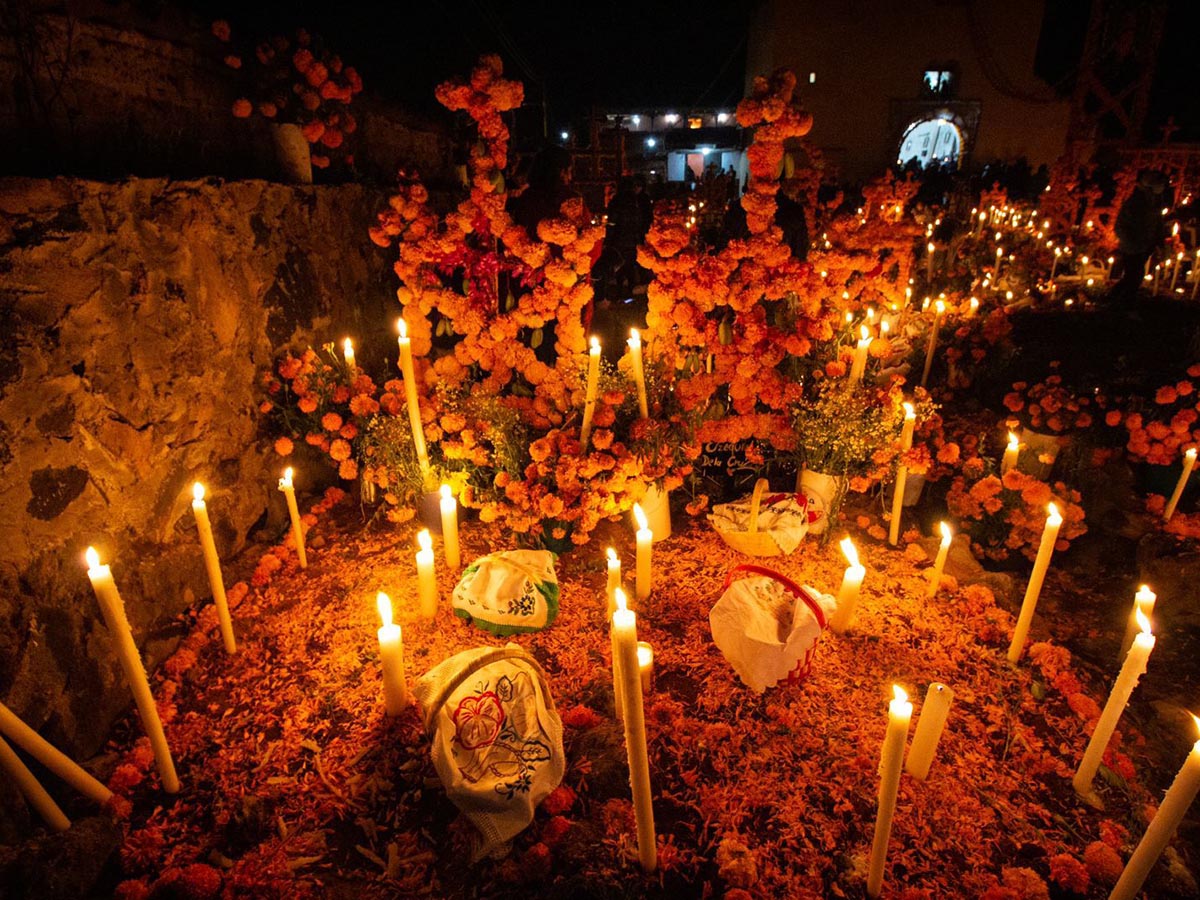 Ofrendas con cempasúchil y velas en un panteón de Michoacán